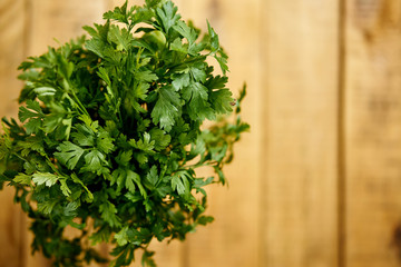 bunch of fresh green parsley on an old wooden kitchen table