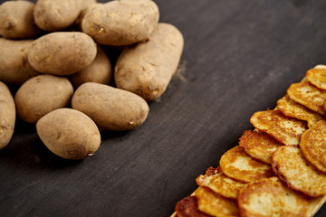 delicious golden potato pancakes on an old wooden black table in the kitchen