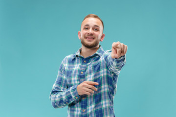 I choose you and order. The smiling business man pointing to camera. portrait on blue studio background. The human emotions, facial expression concept. Trendy colors