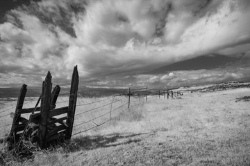 Rolling clouds over country field in black and white