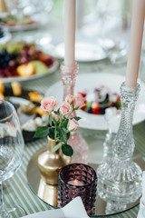 Bouquets of pink and white flowers near the candles on the table.