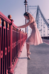 Young ballerina. Nice pleasant woman holding the bridge while standing on the pointe shoes © Viacheslav Yakobchuk