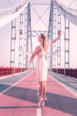 Female dancer. Beautiful nice woman standing on the bridge while dancing © Viacheslav Yakobchuk