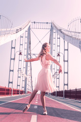 Female dancer. Beautiful nice woman standing on the bridge while dancing © Viacheslav Yakobchuk