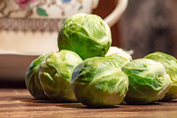 Brussel sprouts on a wooden table with a coffee cup