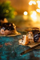 small ricotta cakes with chocolate icing, in Christmas atmosphere. Christmas lights in the background 