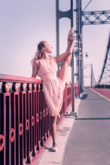 Professional ballerina. Nice attractive woman standing near the parapet on the bridge while showing her flexibility © Viacheslav Yakobchuk
