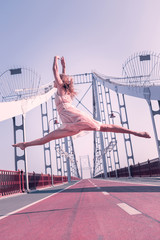 Summer day. Positive nice woman standing on the embankment while showing her flexibility © Viacheslav Yakobchuk