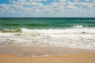 Big breaking Sea wave on a sandy beach on the shore of Sozopol in Bulgaria. Beautiful waves wash the beach with golden sand on a bright summer day.