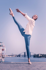 Autumn day. Beautiful professional dancer wearing a stylish coat while standing near the river © Viacheslav Yakobchuk