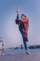 So beautiful. Nice attractive woman standing against the sky while holding her leg up © Viacheslav Yakobchuk