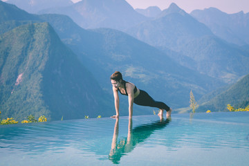 Beautiful Attractive Asian woman practice yoga Plank or Phalakasana Pose on the pool above the Mountain peak in the morning in front of beautiful nature views in SAPA vietnam,Feel so comfortable