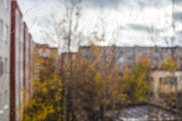 slanting rain on a window in the background an autumn city