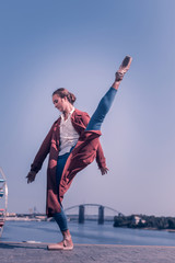 Beautiful movements. Nice professional ballerina dancing while having a performance near the river © Viacheslav Yakobchuk