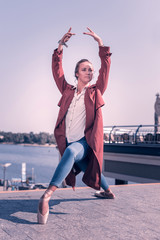 Dancing position. Beautiful young woman holding her hands above the head while dancing © Viacheslav Yakobchuk