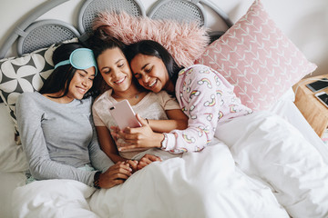 Girls enjoying with mobile phone during a sleepover