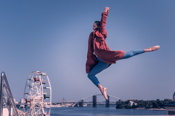 So elegant. Professional female dancer doing a graceful jump while performing near the river © Viacheslav Yakobchuk