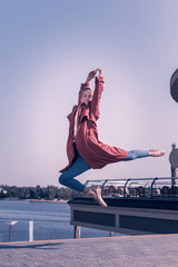 Graceful jump. Nice skilled woman holding her hands together while doing a graceful jump © Viacheslav Yakobchuk