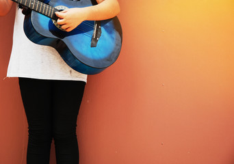 beautiful girl teen playing blue acoustic guitar close up.