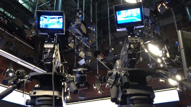 Professional Production Studio. Interior of a production studio focusing on the camera with defocused studio lightings on top.