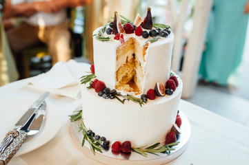 Beautiful cake covered with icing cream, summer berries on the top.