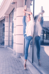Talented dancer. Nice attractive woman standing near the glass door while holding her leg up © Viacheslav Yakobchuk