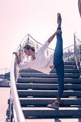 Talented ballerina. Happy nice woman standing on the stairs while showing her dancing skills © Viacheslav Yakobchuk