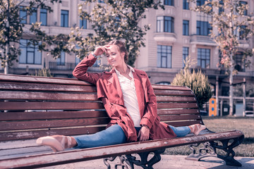 Joyful mood. Positive attractive woman resting on the bench while doing the splits © Viacheslav Yakobchuk