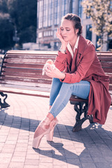 Junk food. Sad cheerless ballerina looking at the hamburger in her hand while wanting to eat it © Viacheslav Yakobchuk