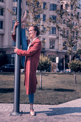 So flexible. Positive joyful woman putting her leg on the lantern while showing her flexibility © Viacheslav Yakobchuk