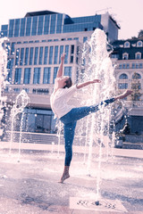 Beautiful fountain. Nice pleasant female dancer holding her leg up while being among the water © Viacheslav Yakobchuk