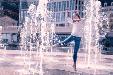 Power of water. Joyful nice woman standing in the fountain while dancing © Viacheslav Yakobchuk