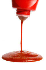 pouring ketchup from bottle on white background