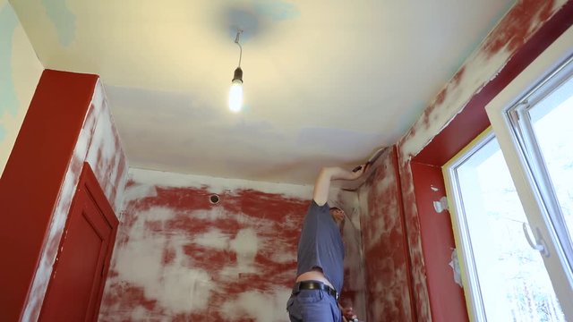 house renovation - worker plastering room ceiling