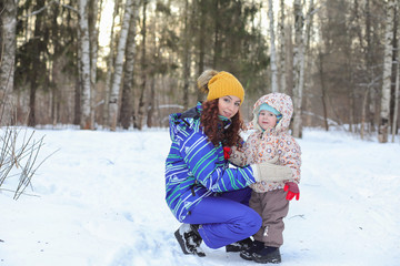Fototapeta na wymiar Kid with family have fun in a winter park