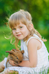 Girl with a cute little rabbit, outdoor, summer day