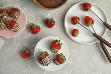 Flat lay composition with chocolate covered strawberries on grey background