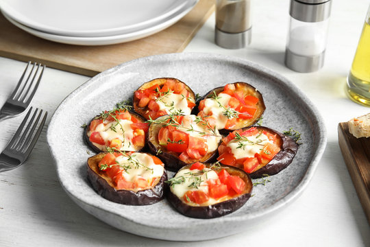 Baked eggplant with tomatoes, cheese and thyme on table