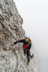 young climbers on a steep and exposed rock face climbing a Via Ferrata