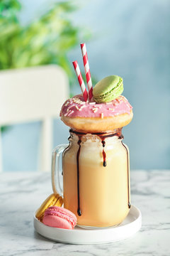 Mason jar with delicious milk shake on table against blurred background