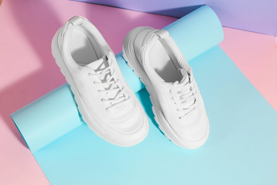 Pair of stylish sneakers on color background