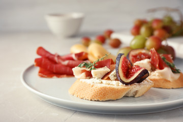 Sandwich with ripe fig, prosciutto and cheese on plate, closeup