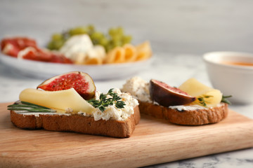 Sandwiches with ripe figs and cheese on wooden board, closeup