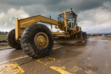 Fototapeta premium Machine to level the ground in the construction of a road