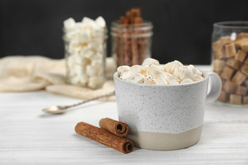 Cup of chocolate milk with marshmallows on wooden table