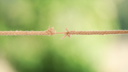Frayed rope at breaking point against blurred background