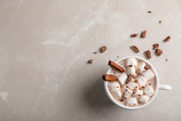 Tasty hot chocolate with milk and marshmallows in cup on table, top view. Space for text