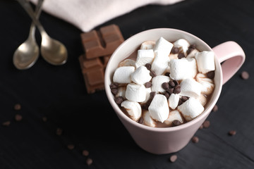 Fototapeta na wymiar Tasty hot chocolate with milk and marshmallows in cup on table