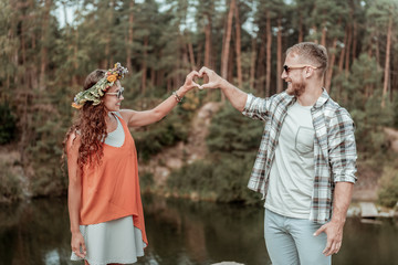 Traveling together. Cute beaming couple wearing sunglasses feeling extremely happy and relaxed while traveling together