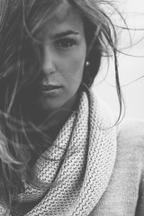 Junge, br&uuml;nette Frau am Strand - Wind in den Haaren